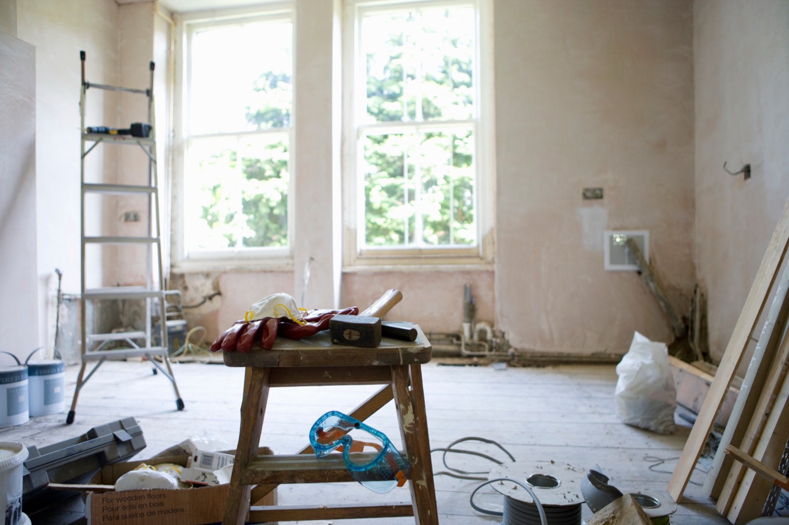 Room mid-renovation with ladder, tools and decorating supplies